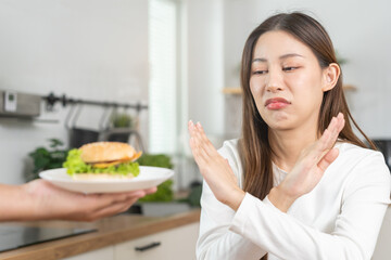 Diet, struggle asian young woman hand gesture reject to eat burger, push out or deny fast, junk...
