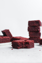 Thick red velvet brownies on a white tray, red velvet fudge brownies on a white background