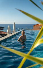 Man swimming in pool by the ocean: Madeira island