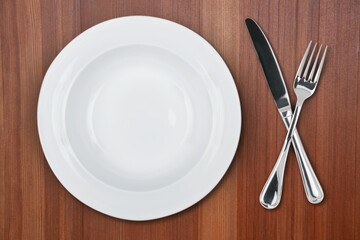Empty white plate with fork, knife, on the desk