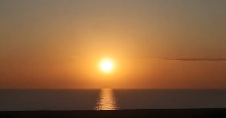 Fototapeta premium Stunning landscape of a golden sun setting over the horizon of a tranquil blue ocean
