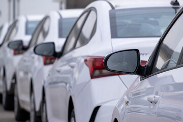 Row of new cars in a dealer's parking lot.