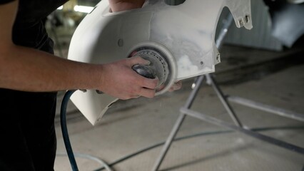 Application of putty when repairing a car body. Professional laborer applies coating on automobile...