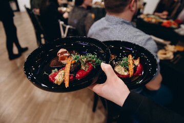 close up view of two dishes with food in waiter hand