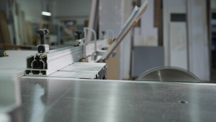 Production, production and woodworking industry concept - carpenter working with sliding panel saw...