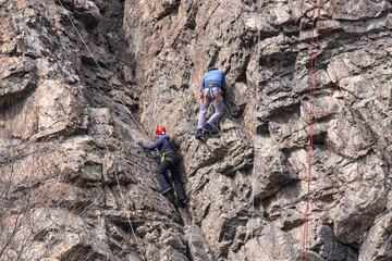 A group of climbers on a vertical rock.
