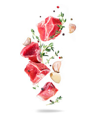 Raw beef meat steaks with garlic and thyme in the air isolated on a white background