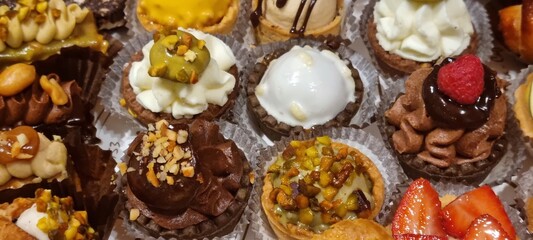 Close-up of a delectable selection of assorted bite-sized french pastries, featuring diverse...