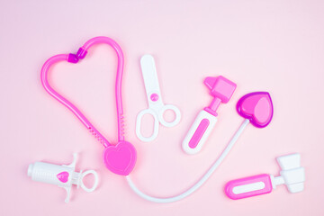 Obraz na płótnie Canvas The concept of a pediatrician. Pediatrics. Toy medical devices on a pink background. Children play professional doctor. Choice of profession. Get vaccinated.