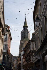 Naklejka premium a normandy turret on a church spire, scenic view along a medieval street, Dinan France