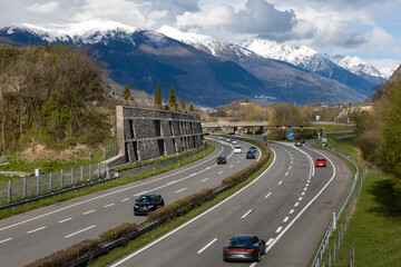 Autoroute entre les montagnes enneigées, en Valais, Suisse - 773346949