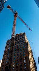 A towering crane lifts a pole, a critical piece in the puzzle of constructing a skyscraper