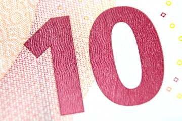 Close-up of a 10 euro banknote fragment on the reverse side, showing the denomination - number 10 . Macro photography. - obrazy, fototapety, plakaty