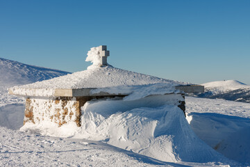 Fototapeta na wymiar Stone chapel, memorial to the victims of the Giant Mountains, Czech republic. Winter sunny day.