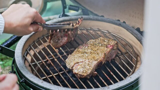 Wonderful Steak Beside Lamb Rib Being Flipped On Ceramic Portable Grill
