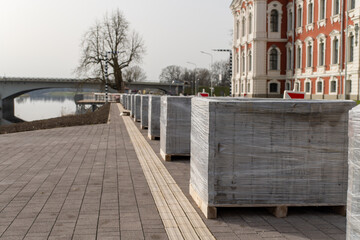 Fototapeta premium Bricks on wood pallet by water, enhancing landscape. Real estate potential