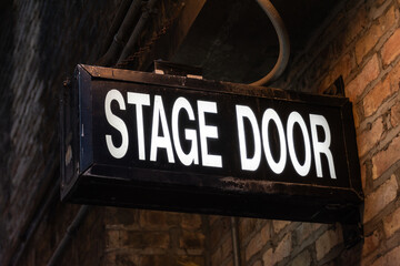 Vintage illuminated stage door sign in a dark and dingy back alley in the city of Chicago,...