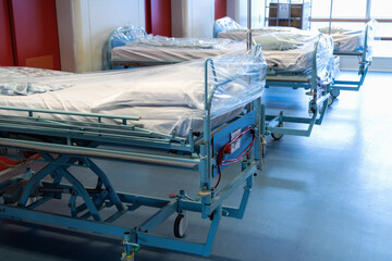 Clean hospital beds covered with film, ready for new patients.