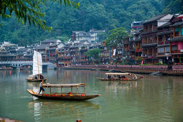 Fototapeta na wymiar Fenghuang, China - September 30 2015: Boats sail in the river of Fenghuang village in China