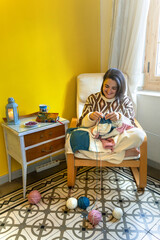 Smiling woman knitting in her stylish home