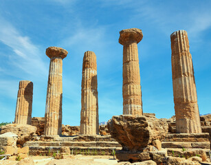 Ruined Temple of Heracles columns in famous ancient Valley of Temples, Agrigento, Sicily, Italy. UNESCO World Heritage Site. - obrazy, fototapety, plakaty