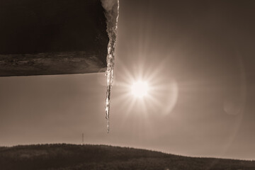Soleil d'hiver qui éclaire un stalactite qui pend d'un toit