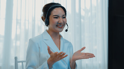 Businesswoman wearing vivancy headset working in office to support remote customer or colleague....