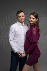 two people, portrait of a pregnant couple on a grey background, pregnant couple close up, future parents, studio pregnancy photo shoot
