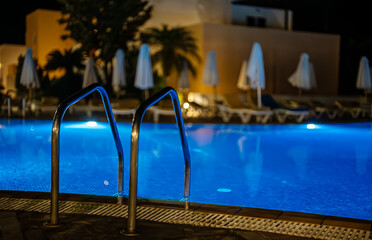 Modern backyard water pool at night.