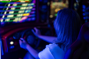 Woman playing racing simulator game in theme park.