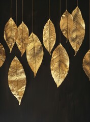 Several gold leaves are suspended from strings, creating a striking display