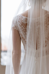Mariée dans robe blanche portant son voile - 773387307