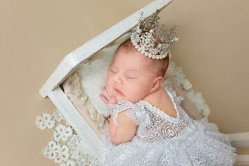little novonarozhena child in her crib. photo session of the newborn. sleepy child, little princess with a crown