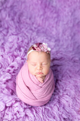 The little newly born child is swaddled in a cocoon. photo session of the newborn. sleeping baby