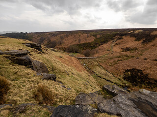 Fields, hills, mountains and a large rock in the foreground. Yorkshire moors. Wild and bleak. Rocky hill top scenic view at dusk