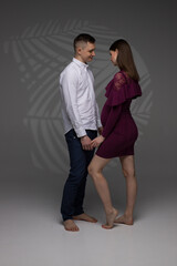 pregnant couple standing on a grey background , fashion pregnant model posing in studio, pregnant woman stands on a grey background, studio shoot