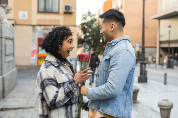 Surprised Woman Receiving Flowers from Partner in City