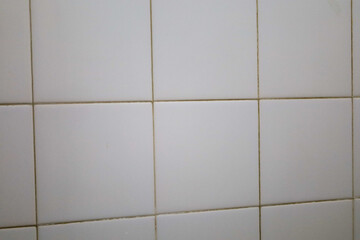 wall covered with white square tiles
