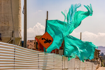 A torn up green shade cloth stirred by the wind, in  a construction site in the colonial town of Villa de Leyva in central Colombia.