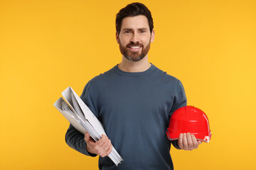 Architect with hard hat and folders on orange background
