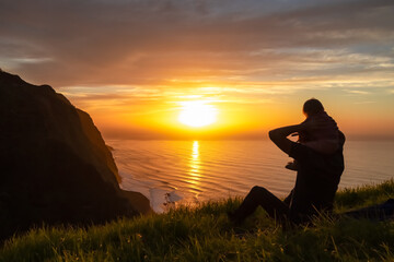 Fototapeta premium Toddler on shoulder of father on meadow with breathtaking sunset at viewing point Miradouro do Ponta da Ladeira, Madeira island, Portugal, Europe. Panoramic view of majestic coastline Atlantic Ocean