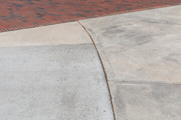 Concrete pads abutting brick walkway, staggered seams with creative copy space, horizontal aspect