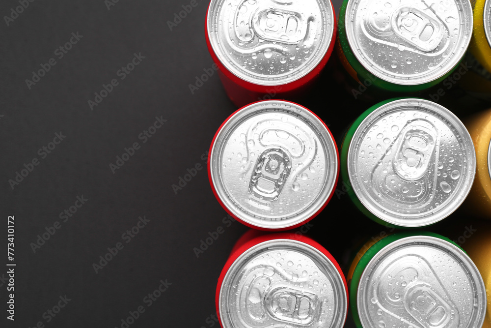 Wall mural Energy drinks in wet cans on dark background, top view. Space for text