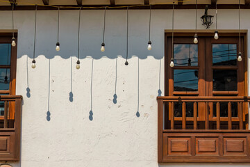 Some hanging bulbs cast their shadow on a white wall in the afternoon, in the colonial town of Villa de Leyva in central Colombia.