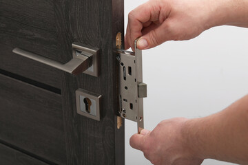 Handyman changing door handleset indoors, closeup view