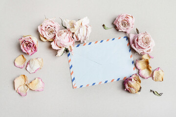 An old blue french envelope and many roses around it, copy space.