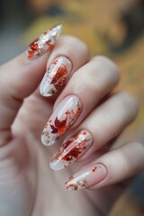 A womans hand is shown with intricate red and white designs on the nails, creating a striking and stylish manicure