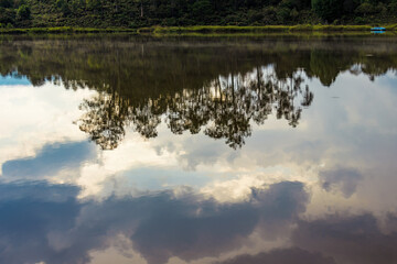 The reflection of a forest in a hill on the calm waters of a lagoon in the eastern Andean mountains of central Colombia.