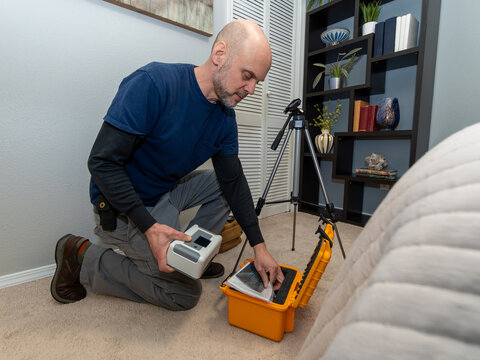 Home inspector doing a radon test setup in the lowest bedroom of a home.