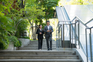 Business colleagues walking and talking outdoors